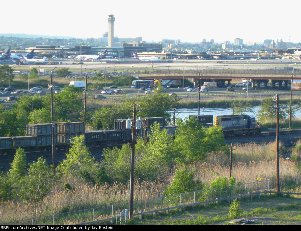 An SD40-2 switches train cars in the shadow of Newark Airport